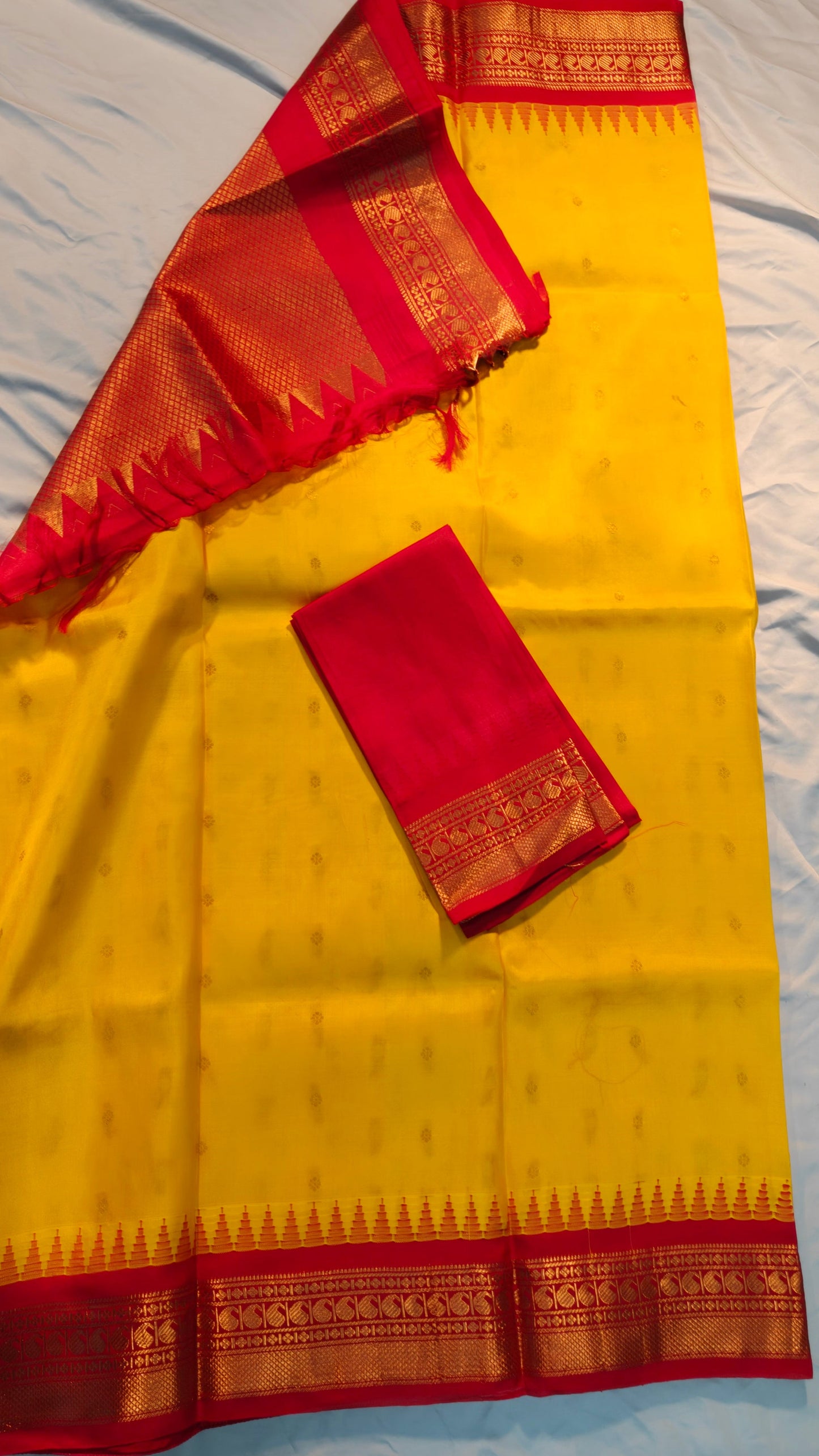 Yellow saree with red border on a white background