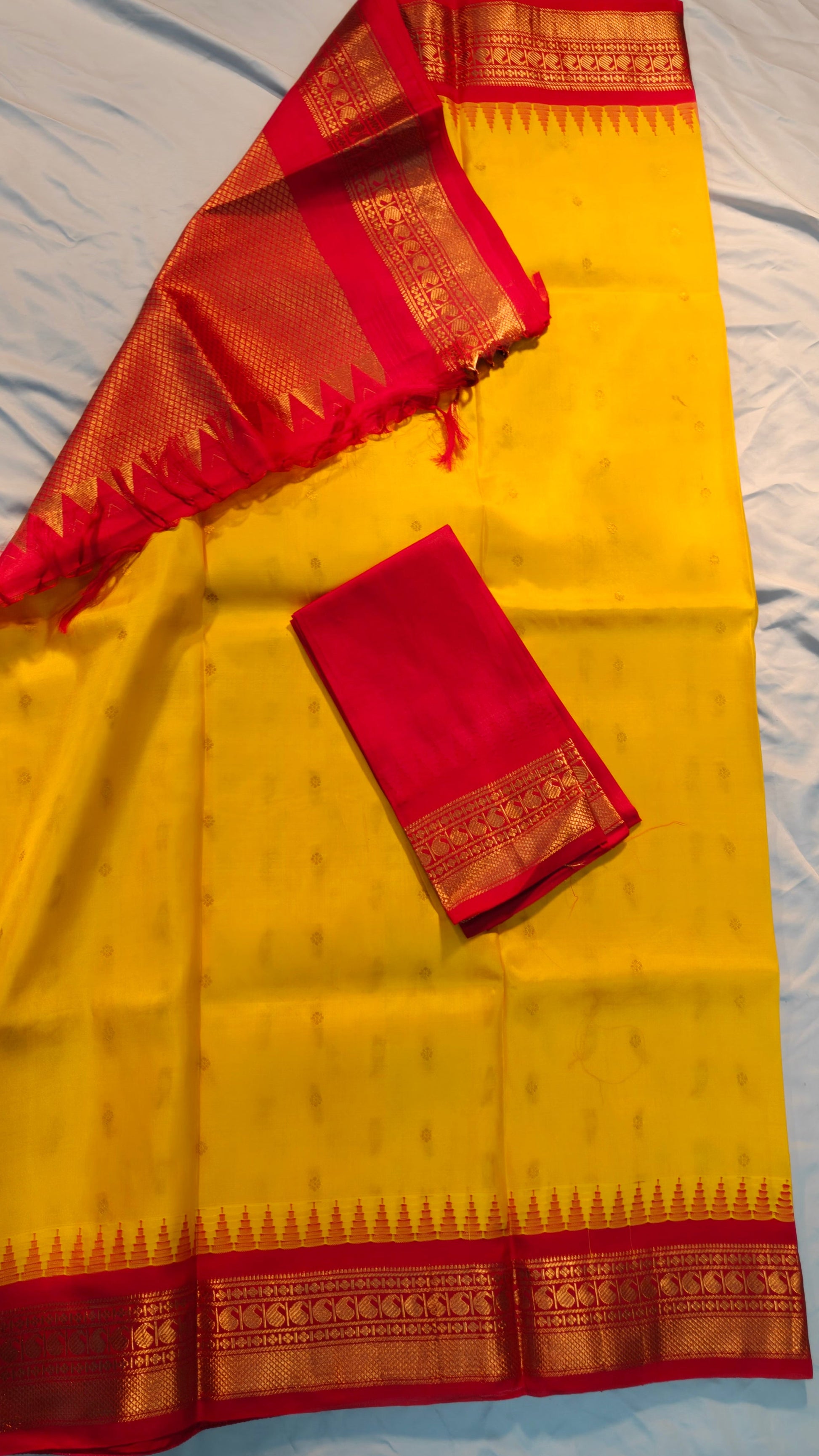 Yellow saree with red border on a white background