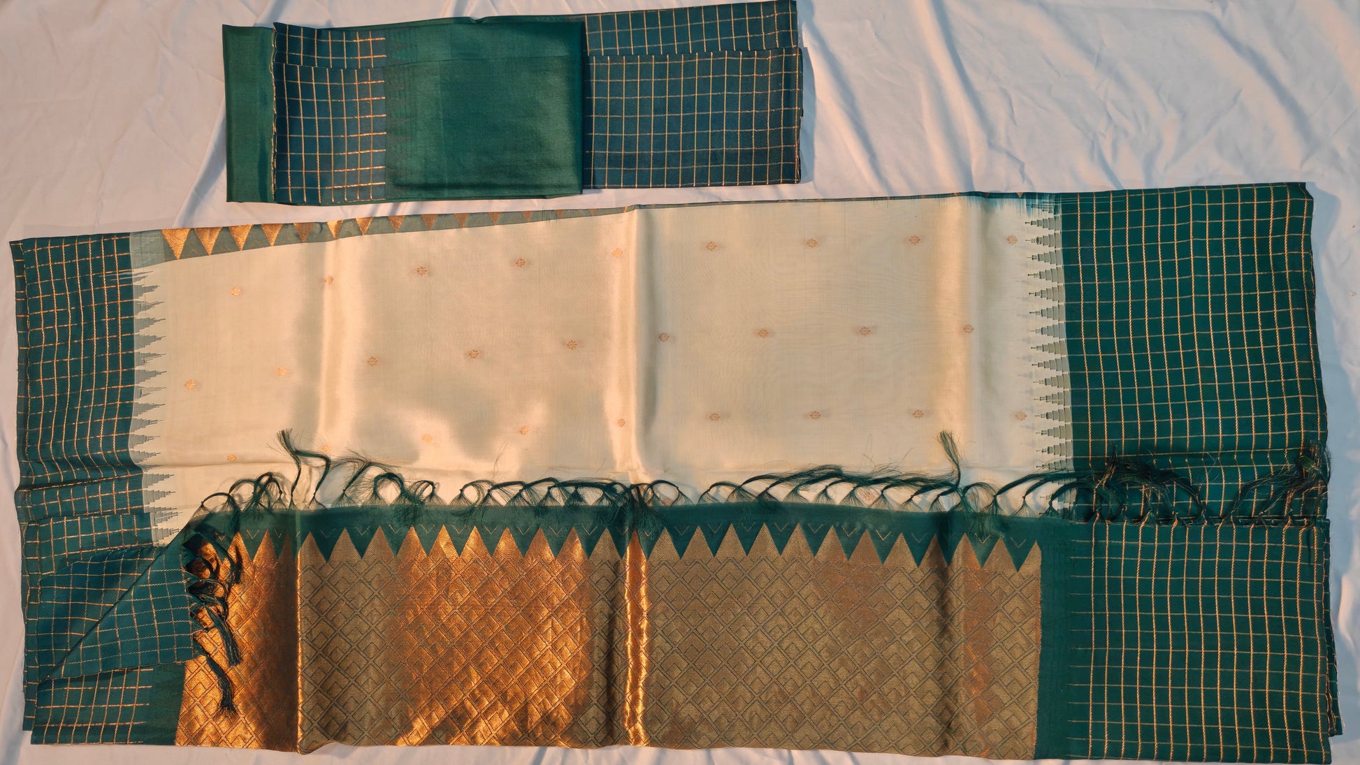 Traditional saree with green and gold patterns on a white background