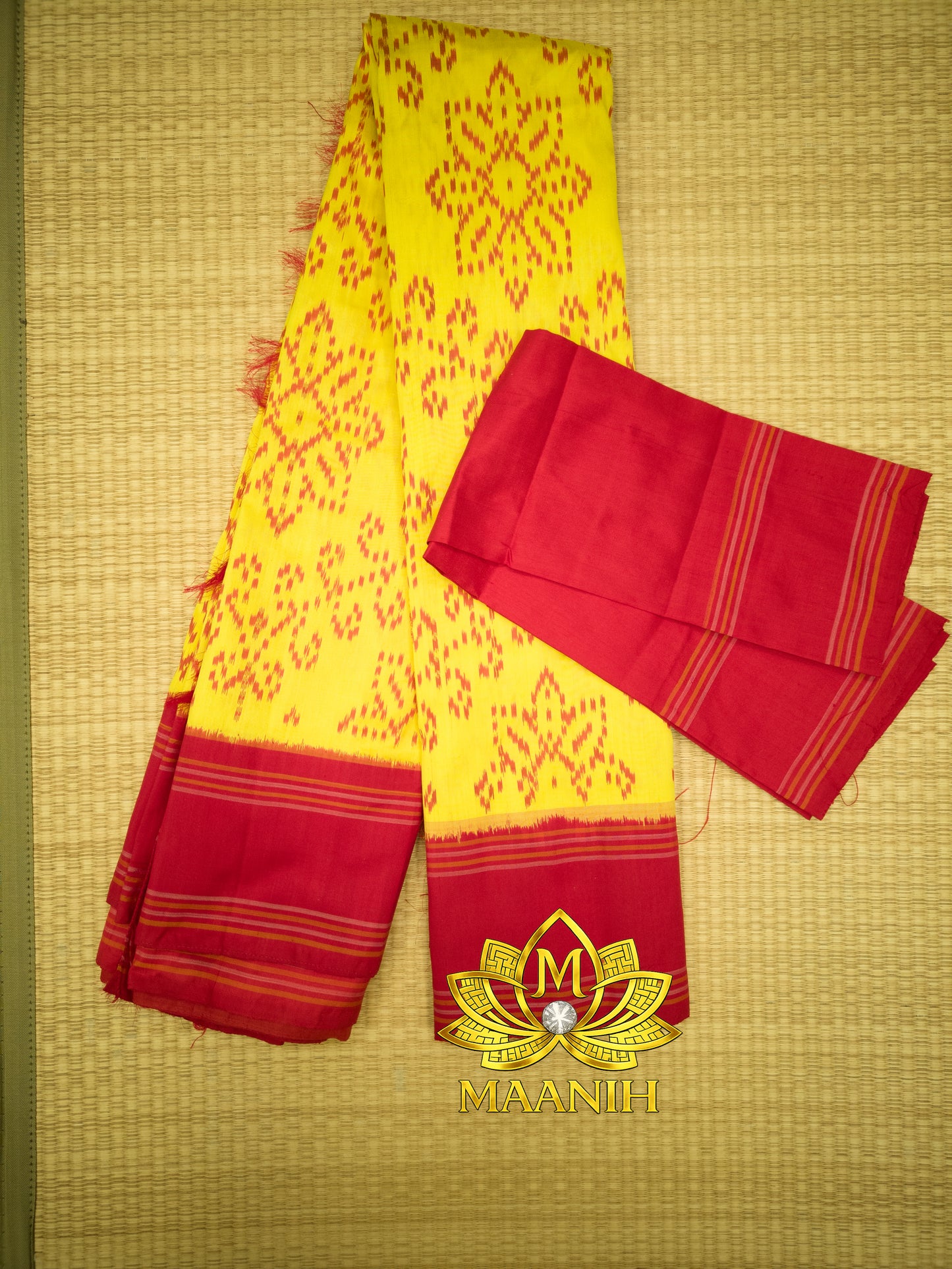 Yellow and red saree with a visible brand logo on a textured background