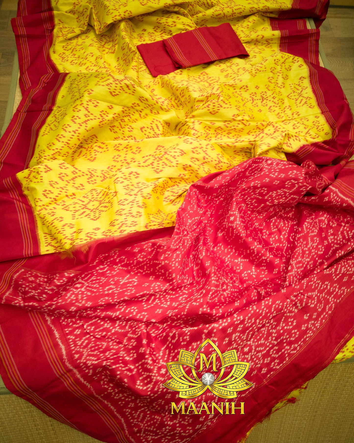 Red and yellow saree with a visible brand logo on a chair